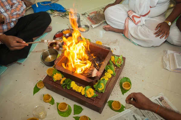 Priests performing a home havan fire ceremony